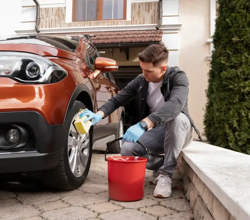 Lavage auto à domicile Le Plessis-Luzarches : professionnel intervenant sur un véhicule